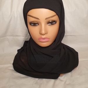 May include: A black chiffon hijab with a gathered style. The hijab is worn on a mannequin head.
