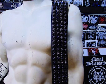 May include: A black leather belt with silver pyramid-shaped studs. The belt is shown on a mannequin.