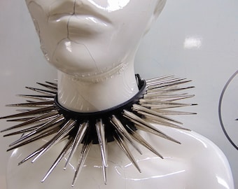Könnte beinhalten: Ein schwarzer Leder-Choker mit silbernen Spikes. Die Spikes sind in einem Kreis um den Choker angeordnet.