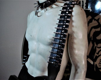May include: A black leather guitar strap with silver bullet casings and a chain detail.