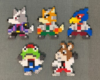 May include: Five pixel art characters made of colorful beads. The characters are a wolf, a fox, a bird, a frog, and a dog. Each character is wearing a white coat and has a different colored accent.