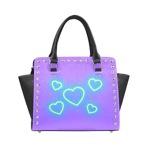 May include: A purple handbag with a black trim and studded details. The bag has a design of neon yellow hearts on a purple gradient background.