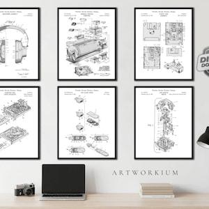 May include: A set of six black and white United States Patent Office technical drawings displayed in black frames. The prints feature detailed schematics for headphones, a camera, a floppy disk, a disk drive, a flash drive, and a joystick.