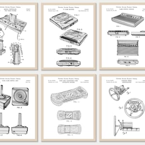 Op de afbeelding: Zes ingelijste patentprints met vintage videogamecontrollers en -consoles. De zwart-wit illustraties bevatten een joystick, handheld console en stuurwiel, met technische diagrammen en labels. De prints zijn gelabeld met "DIGITAL DOWNLOAD" en "ARTWORKIUM".