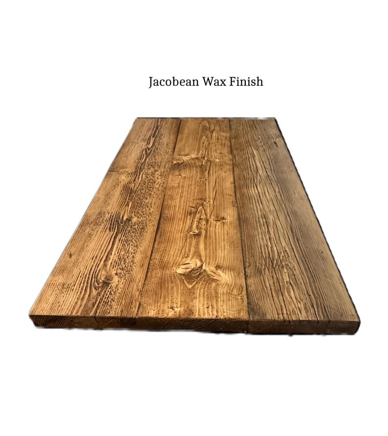 May include: A rectangular wooden tabletop or board featuring a dark brown Jacobean wax finish. The surface displays a prominent natural wood grain pattern, visible knots, and textured vertical lines across three joined planks of wood.