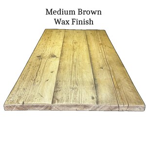 May include: A rectangular wooden tabletop featuring a medium brown wax finish. The surface is composed of three joined planks displaying natural wood grain patterns, knots, and visible texture. The text Medium Brown Wax Finish is centered above.