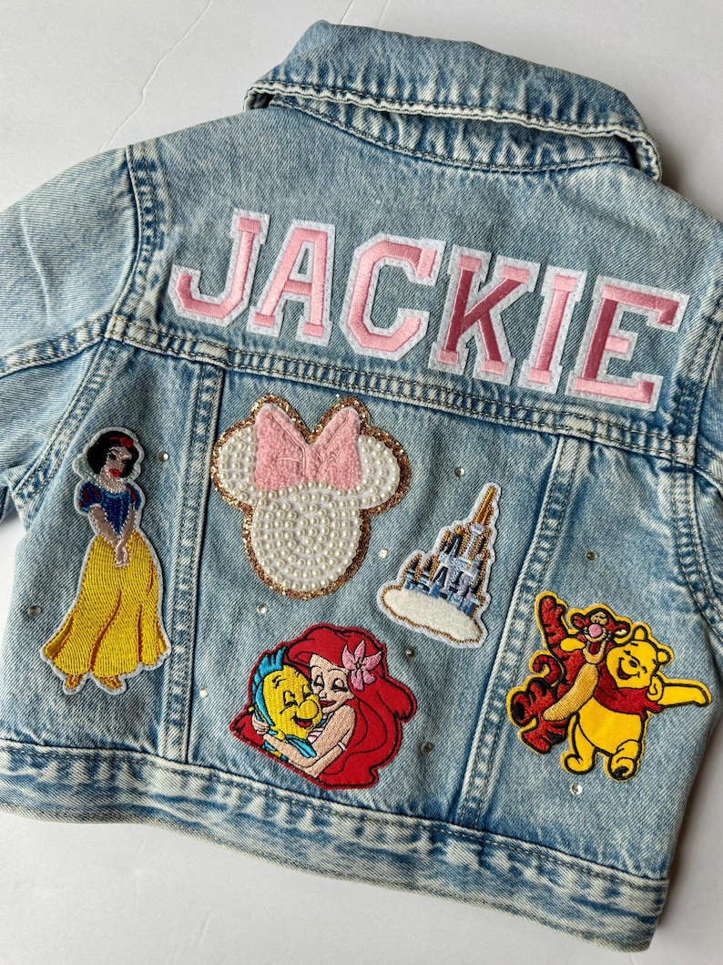 May include: A white ceramic mug with a black handle and the text "But First, Coffee" in a black, bold font. The mug is on a white surface.