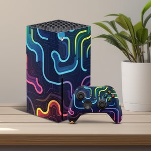 May include: A black Xbox Series X console with a colorful abstract design and a matching black Xbox controller with the same design.