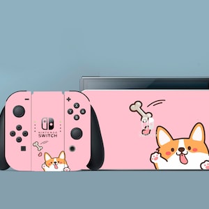 May include: Pink Nintendo Switch console and Joy-Con controllers featuring a cute cartoon Corgi dog design. The design includes a Corgi dog with a bone in its mouth, and the text "Nintendo Switch".