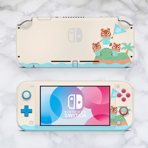 Könnte beinhalten: Cremefarbene Nintendo Switch Lite Konsole mit Animal Crossing-Design. Sie hat ein blaues Wellenmuster, Inselgrafiken und das Nintendo Switch-Logo. Der Bildschirm zeigt ein abstraktes rosa und blaues Design. Blaue Knöpfe.