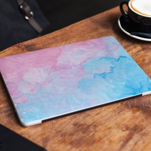 Op de afbeelding: Een laptop skin met een abstract marmerontwerp in roze en blauw. De skin heeft een glanzende afwerking en is gemaakt van duurzaam vinyl.