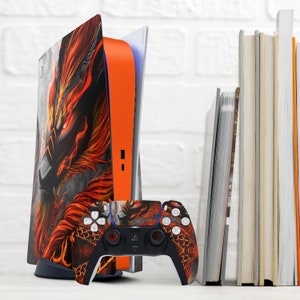 May include: A black and orange video game console with a dragon design on the front. The console is next to a black and orange video game controller.