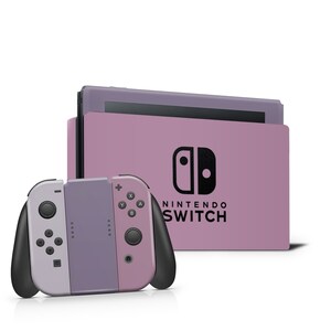 Op de afbeelding: Een paarse en grijze Nintendo Switch-console met een bijpassende Joy-Con-controller. De console heeft het Nintendo Switch-logo en de tekst "NINTENDO SWITCH" erop gedrukt.