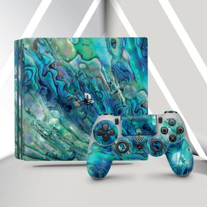 May include: A blue and green patterned console and controller for a PlayStation gaming system. The pattern resembles a seashell.