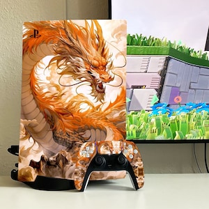 Op de afbeelding: Een witte PlayStation 5 console met een aangepaste skin met een gouden draakontwerp. De console staat op een zwarte standaard en een bijpassende controller staat er voor.