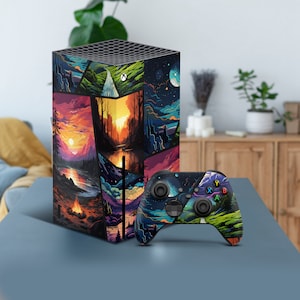 May include: A black and colourful video game console with a landscape design and a matching black and colourful controller.