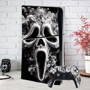 Peut inclure: Une console de jeu noire et blanche avec un motif de masque Scream. La console est placée contre un mur de briques blanches, avec un appareil photo vintage et un vase de fleurs rouges à proximité.