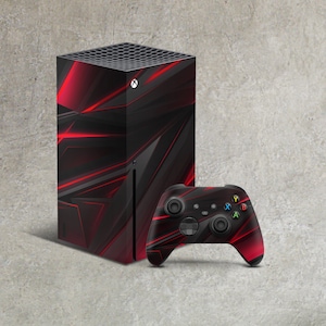 May include: A black and red video game console with a geometric design and a matching black and red controller.