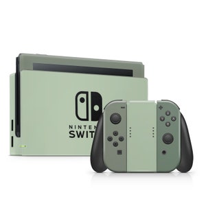 Könnte beinhalten: Eine grüne Nintendo Switch Konsole mit einem passenden grünen Joy-Con Controller. Die Konsole hat das Nintendo Logo und die Worte "NINTENDO SWITCH" auf der Vorderseite.