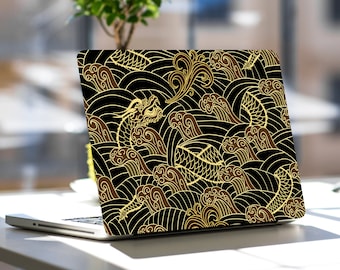 Könnte beinhalten: Ein schwarzer Laptop mit einem goldenen und braunen Drachen- und Wellenmuster auf dem Deckel.