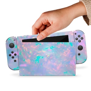 May include: A light blue and iridescent Nintendo Switch console skin with a swirling opal pattern. The skin is shown on a Nintendo Switch console with the screen open.