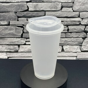 May include: A clear, frosted plastic cup with a matching lid. The cup is cylindrical with a slightly flared rim and a raised base. The lid has a drinking spout and a secure fit. The cup is designed for cold beverages.