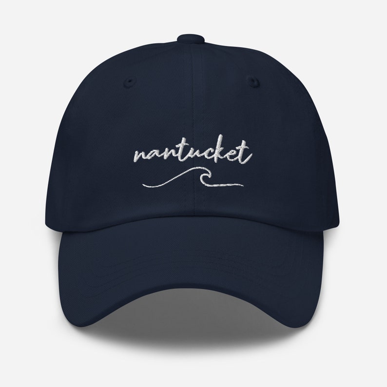 May include: A navy blue baseball cap with white embroidered text that says "nantucket" with a wave underneath.