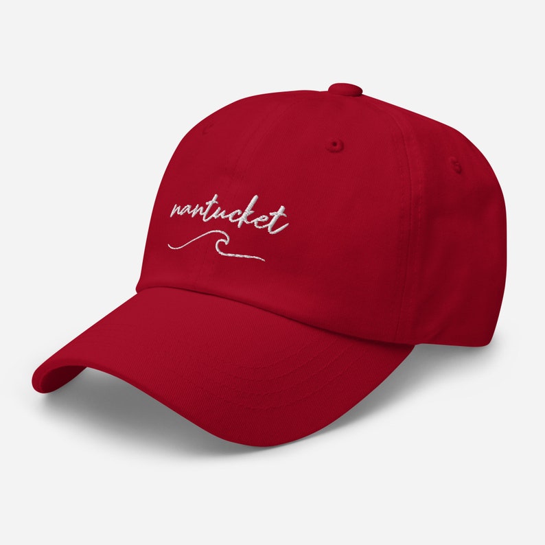 May include: A red baseball cap with a white embroidered wave and the text "nantucket" on the front.