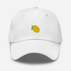 May include: White baseball cap with an embroidered lemon design.
