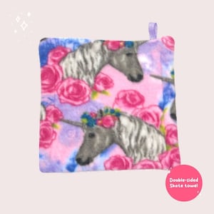 May include: Double-sided skate towel with a pink and purple background featuring a unicorn and floral pattern. The text "Double-sided Skate towel" is printed on the bottom right corner.