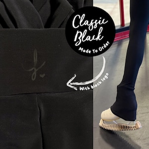 以下が含まれることがあります： ハイウエストの黒いレギンスと小さなロゴ。画像には「Classic Black Made To Order With black logo」というテキストが含まれています。レギンスは、テクスチャード加工されたソールを備えたクリーム色の靴と組み合わせています。