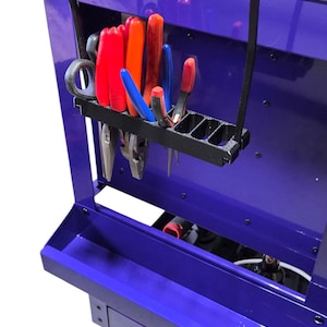 May include: A deep purple rolling tool chest with a variety of hand tools. The tools include pliers, wrenches, and screwdrivers. The chest has a black tool holder and a lower tray. The chest is on wheels.