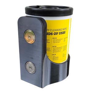 May include: A black, wall-mounted cleaning wipe dispenser with a yellow and white container. The container has the text "TY CLEANING WIPE" and "IDS OF USES". The dispenser has two metallic fasteners.