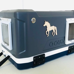 May include: A dark gray pet carrier with a white and navy blue trim, featuring a light-colored unicorn silhouette. The carrier has two pet doors, a handle, and the word "OOTB" embossed on the side.