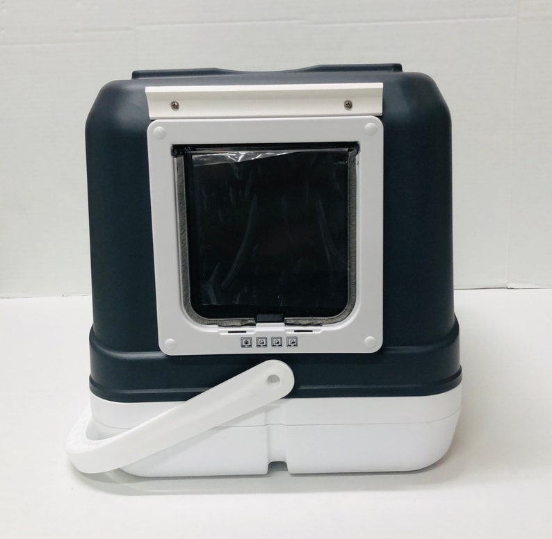 Puede incluir: Arenero para gatos de dos tonos, con una secci&oacute;n superior gris oscuro y una secci&oacute;n inferior blanca. Cuenta con una puerta enmarcada en blanco con una solapa negra y un asa blanca. La caja tiene forma rectangular y est&aacute; dise&ntilde;ada para uso de mascotas.