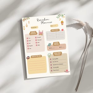 May include: A printable Ramadan planner with a pink and brown color scheme. The planner includes sections for daily goals, prayer checklist, Quran tracker, and good deeds checklist. The planner features a mosque illustration and a cute cartoon character.