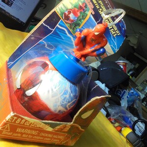 May include: A Spider-Man themed bath gel container in a red and blue spherical bottle with a molded Spider-Man figure on top. The product is housed in a cardboard display box featuring lightning graphics and the text NET 8 fl oz (236 ml).