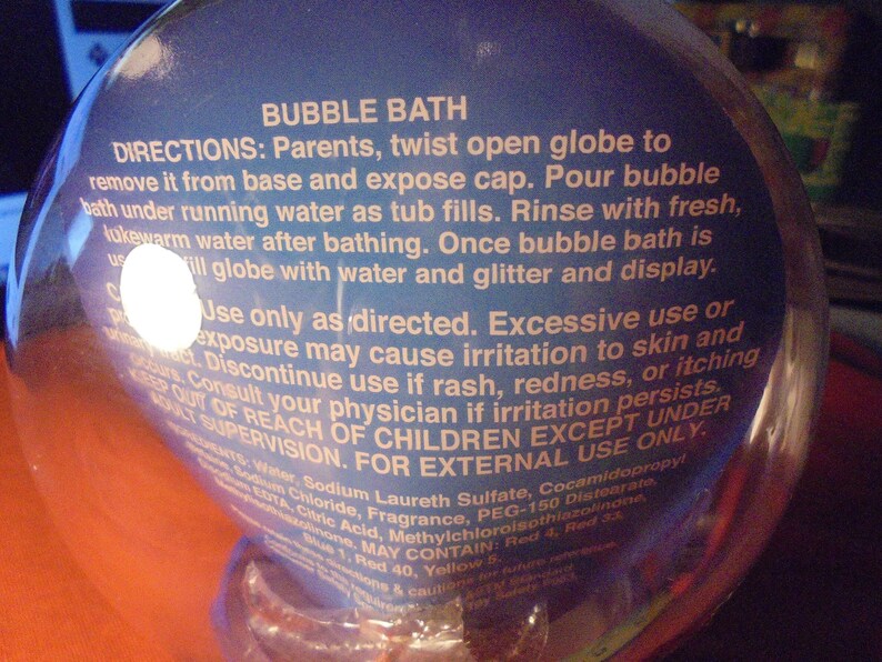 May include: A clear, spherical bubble bath container with blue label text. The label provides directions for use, including warnings about skin irritation and the need for adult supervision. The product is for external use only.