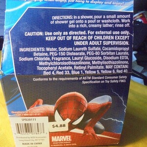 May include: A blue cardboard product box featuring a Spider-Man graphic, directions for shower gel use, caution warnings, and a full list of ingredients including water, sodium laureth sulfate, and various colorants. A barcode and Marvel logo are visible.