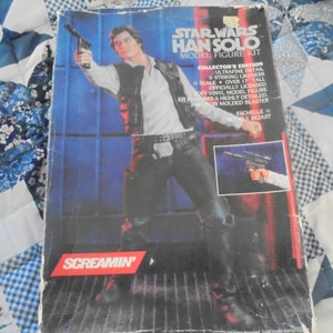 May include: A Star Wars Han Solo model figure kit collector's edition box. The box features a photo of Han Solo holding a blaster, with the text "Star Wars Han Solo Model Figure Kit" and "Collector's Edition" on the front.
