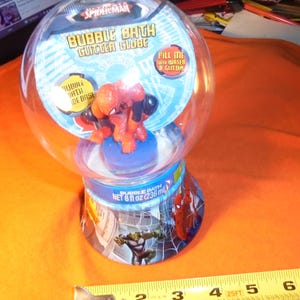 May include: A Spider-Man Bubble Bath Gutter Globe. The clear plastic globe contains a Spider-Man figurine. The base of the globe has images of Spider-Man and the Hulk. The product contains 8 fl oz (236 ml) of bubble bath.