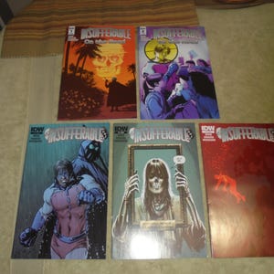 May include: A collection of five comic books titled "Insufferable." The covers feature various illustrations, including a skull, figures in action, and a skeletal figure. The color palette includes shades of red, blue, and orange.