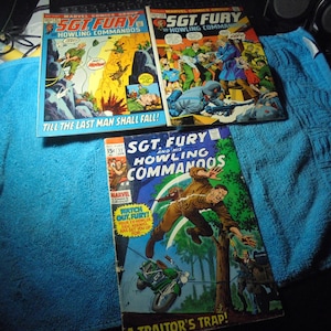 May include: Three vintage comic books featuring "Sgt. Fury and his Howling Commandos." The covers display action-packed scenes with vibrant colors. One comic has the text "Till the Last Man Shall Fall!" and another reads "A Traitor's Trap!"