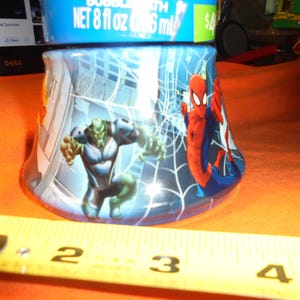 May include: A blue bubble bath bottle featuring Spider-Man and the Green Goblin. The bottle has a cityscape background with a spider web design. The bottle contains 8 fl oz of bubble bath.