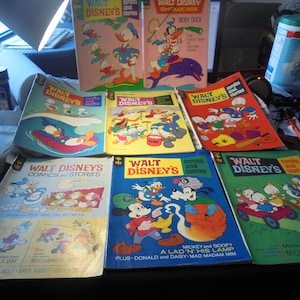 May include: A collection of vintage Walt Disney comics and story books. The covers feature various Disney characters, including Mickey Mouse, Donald Duck, Goofy, and others. The comics are in good condition and have colorful covers.