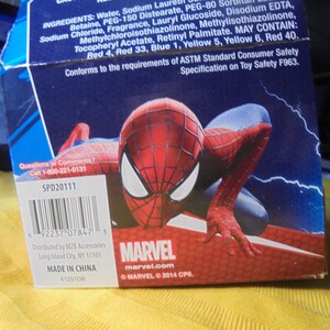 May include: A blue cardboard product box featuring a graphic of the Marvel character Spider-Man in a crouching pose. The box includes a barcode, the text Marvel, and a list of ingredients printed in white against a dark blue background.