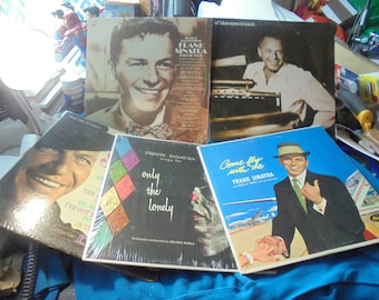 May include: A collection of five square vinyl record jackets featuring Frank Sinatra. The covers display various portraits of the artist, including titles like In The Beginning, Ol' Blue Eyes Is Back, Only The Lonely, and Come Fly With Me.