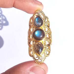 May include: Gold ring with three iridescent blue-grey labradorite gemstones set in a filigree design.