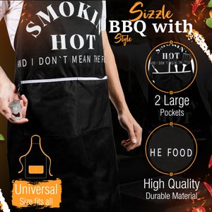 Puede incluir: Un delantal de barbacoa negro con texto blanco que dice "Smokin' Hot and I don't mean the food." El delantal tiene dos bolsillos grandes y un abridor de botellas sujeto a la parte delantera. El delantal lo lleva puesto una persona. El texto "Sizzle BBQ with Style" est&aacute; en la esquina superior derecha de la imagen.