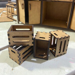 May include: Three wooden crates with black trim, stacked on top of each other. The crates are made of unfinished wood and have a rustic look.